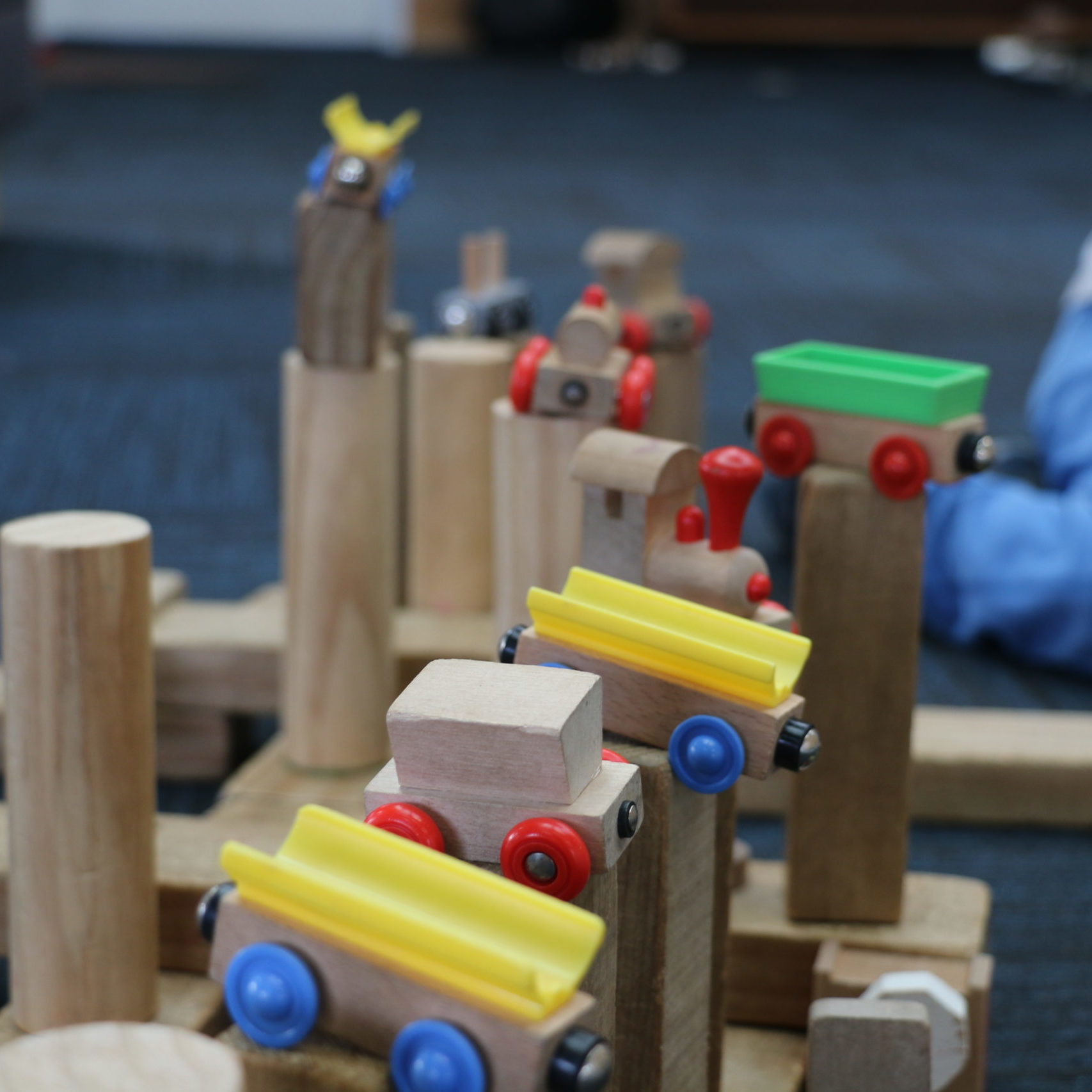 wooden blocks with toy trains stacked on top