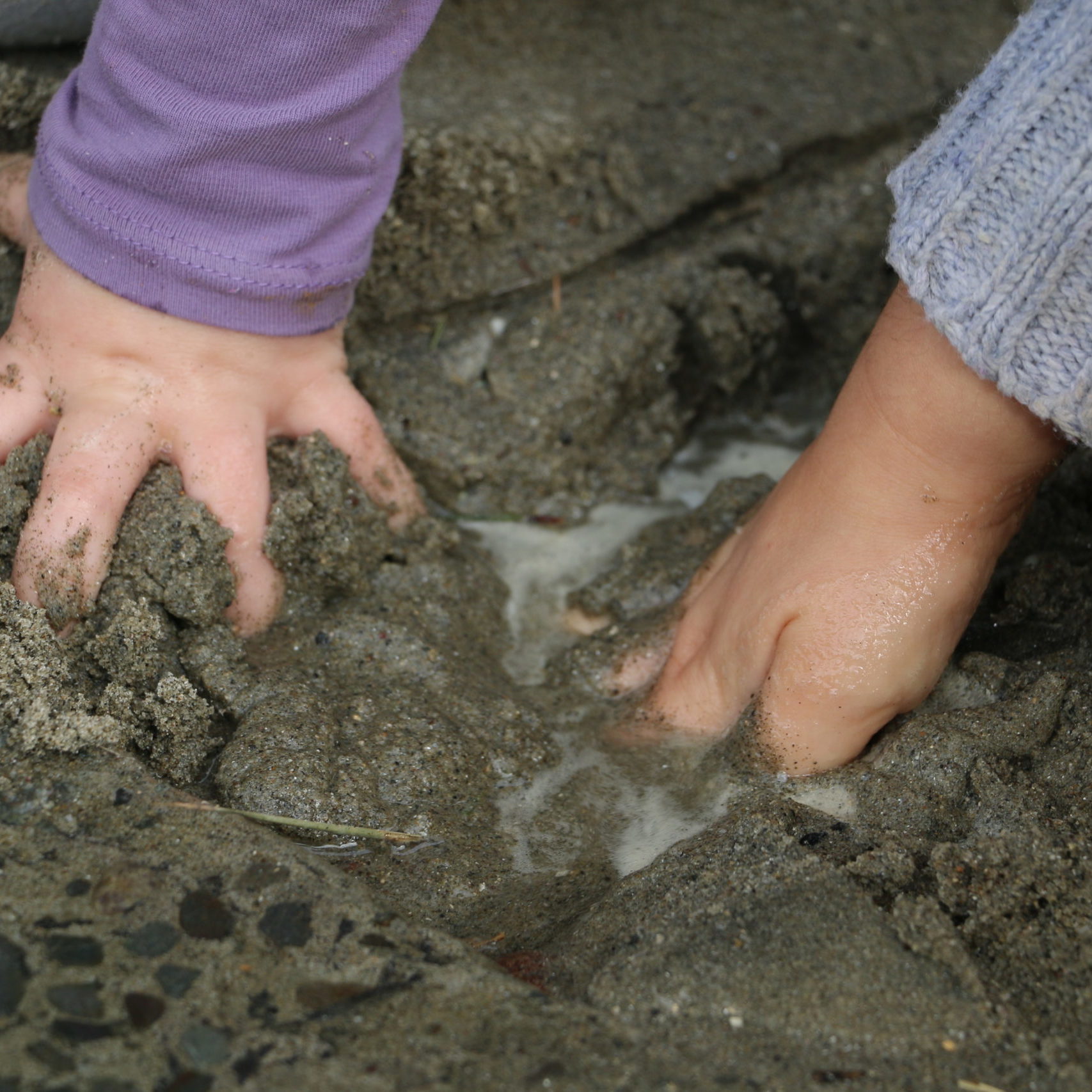 Children hands grabbing sand